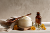 Natural skincare scene with glass cosmetic jar filled with whipped tallow
