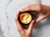 Ever Tallow Balm as a flat lay.  Held by two hands from the right of the frame.