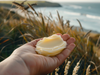 NZ Beef tallow in the hand with a New Zealand beach background