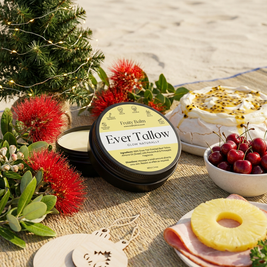Ever Tallow Fruity Balm on a table with Christmas decorations and food
