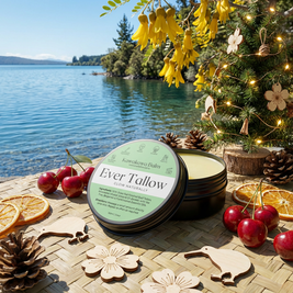 Ever Tallow kawakawa balm packaging on a wooden surface with a scenic lake background