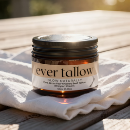 Jar of 'ever tallow' cream on a white cloth with a blurred natural background