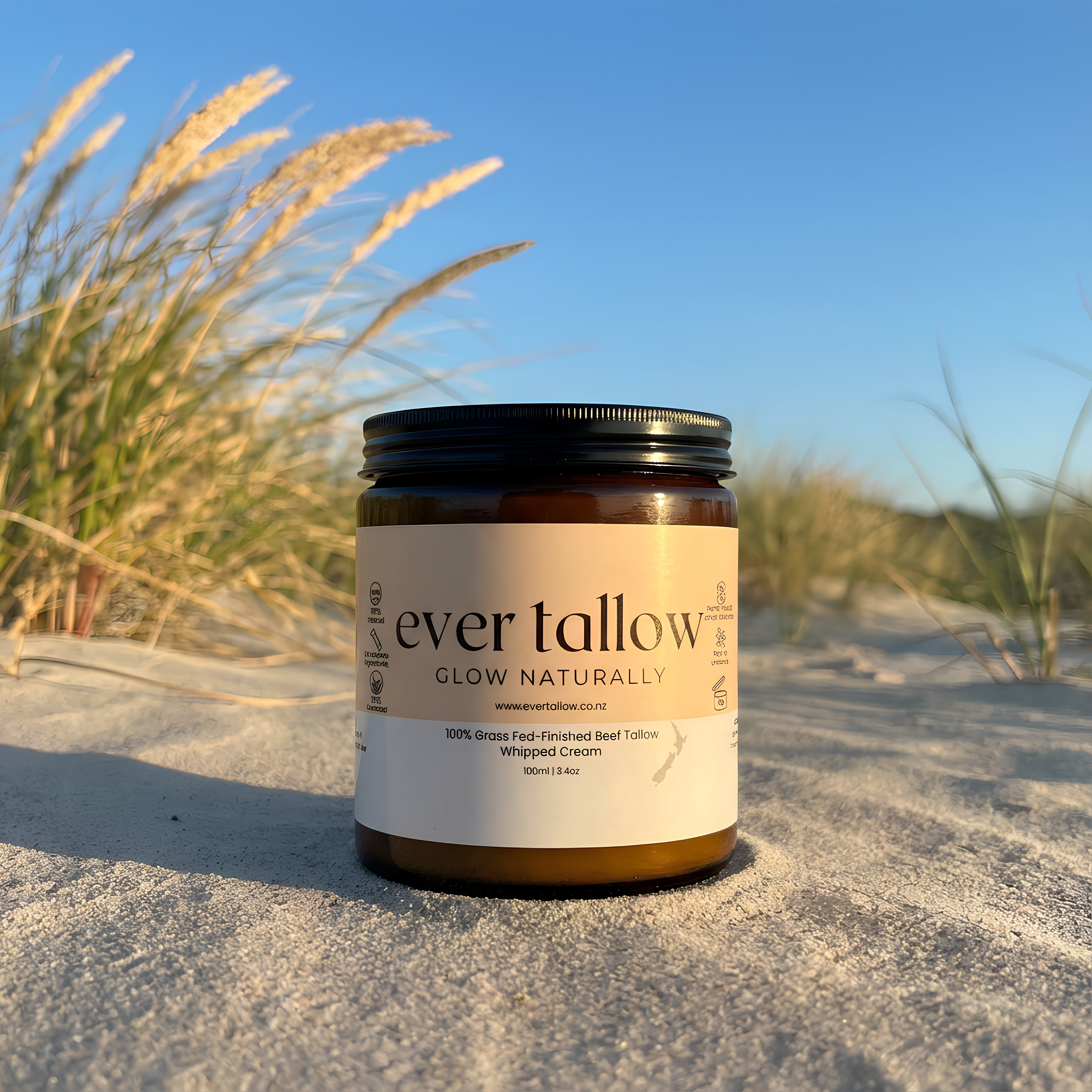 Ever Tallow, Bare Tallow jar on a sandy beach with grasses and clear sky