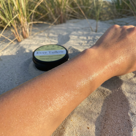 Close-up of dewy sunlit skin at the beach. Soft highlight on hydrated texture. Warm golden NZ summer light.