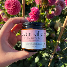 Ever Tallow Beef Tallow with Jojoba Oil, Frankincense, and Rose in front of dahlias in the garden