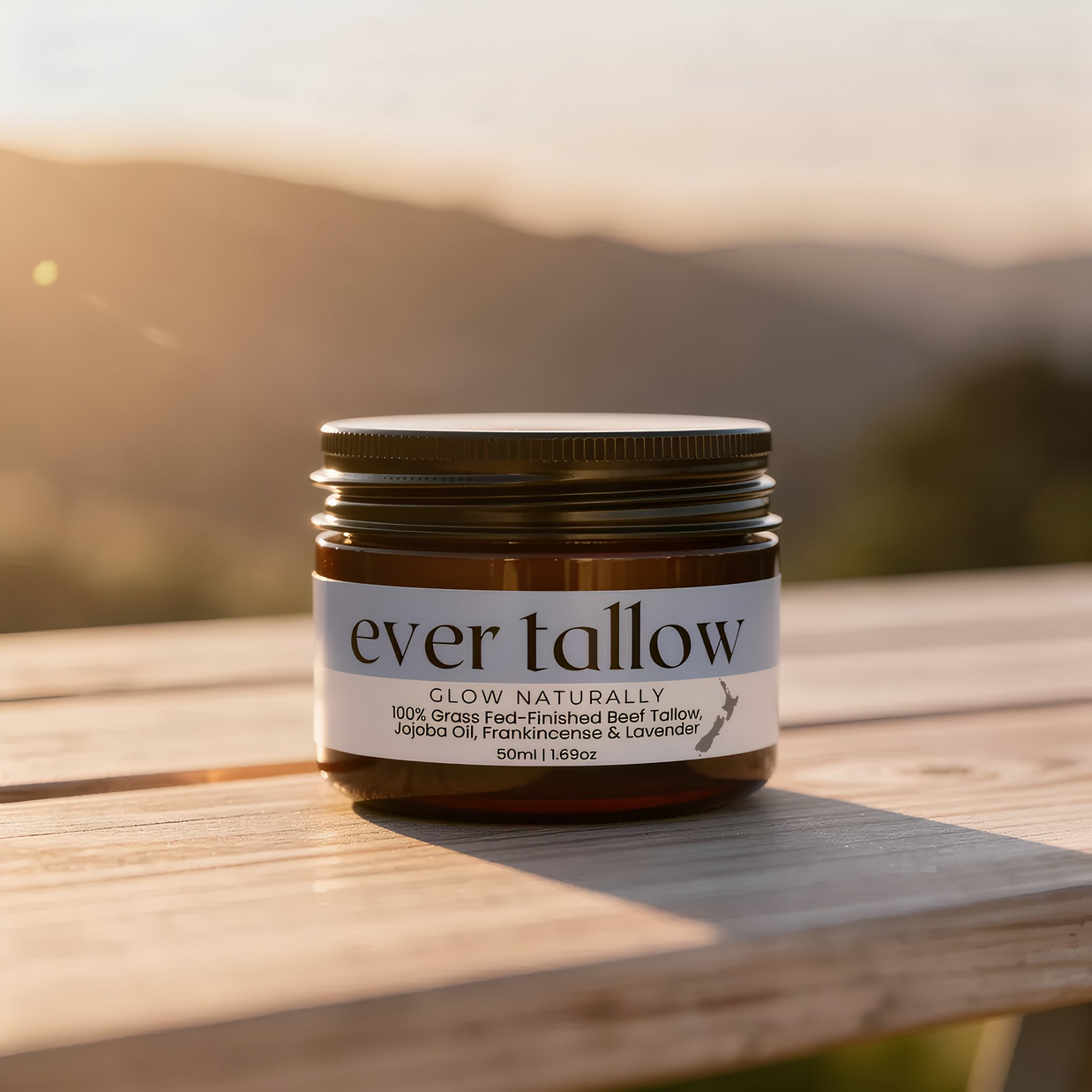 Jar of 'ever tallow' on a wooden surface with a mountainous background