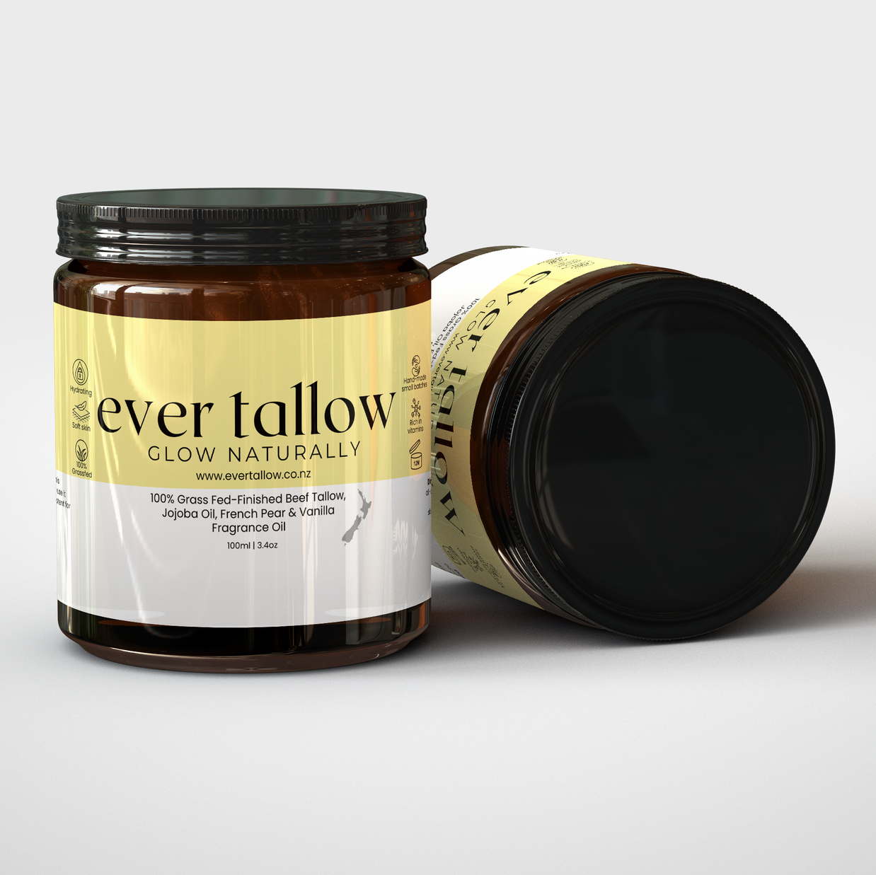 Two amber glass jars of French Pear and Vanilla Whipped Tallow on a light gray background, one standing upright showing the front label and one lying on its side showing the side label.