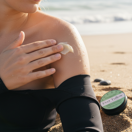 Person applying sunscreen to shoulder with beach background