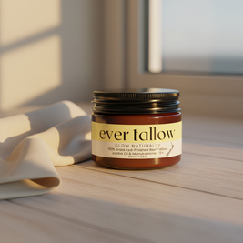 Jar of 'ever tallow' product on a wooden surface with soft lighting