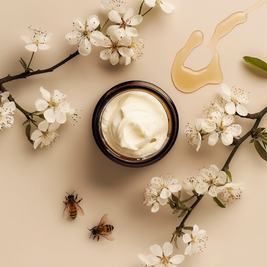 Manuka Honey Tallow Jar of cream surrounded by white flowers and bees on a beige background