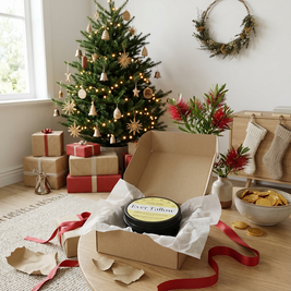 Christmas-themed room with a tree, presents, and a box of Ever Fallow Fruity Balm on a table.